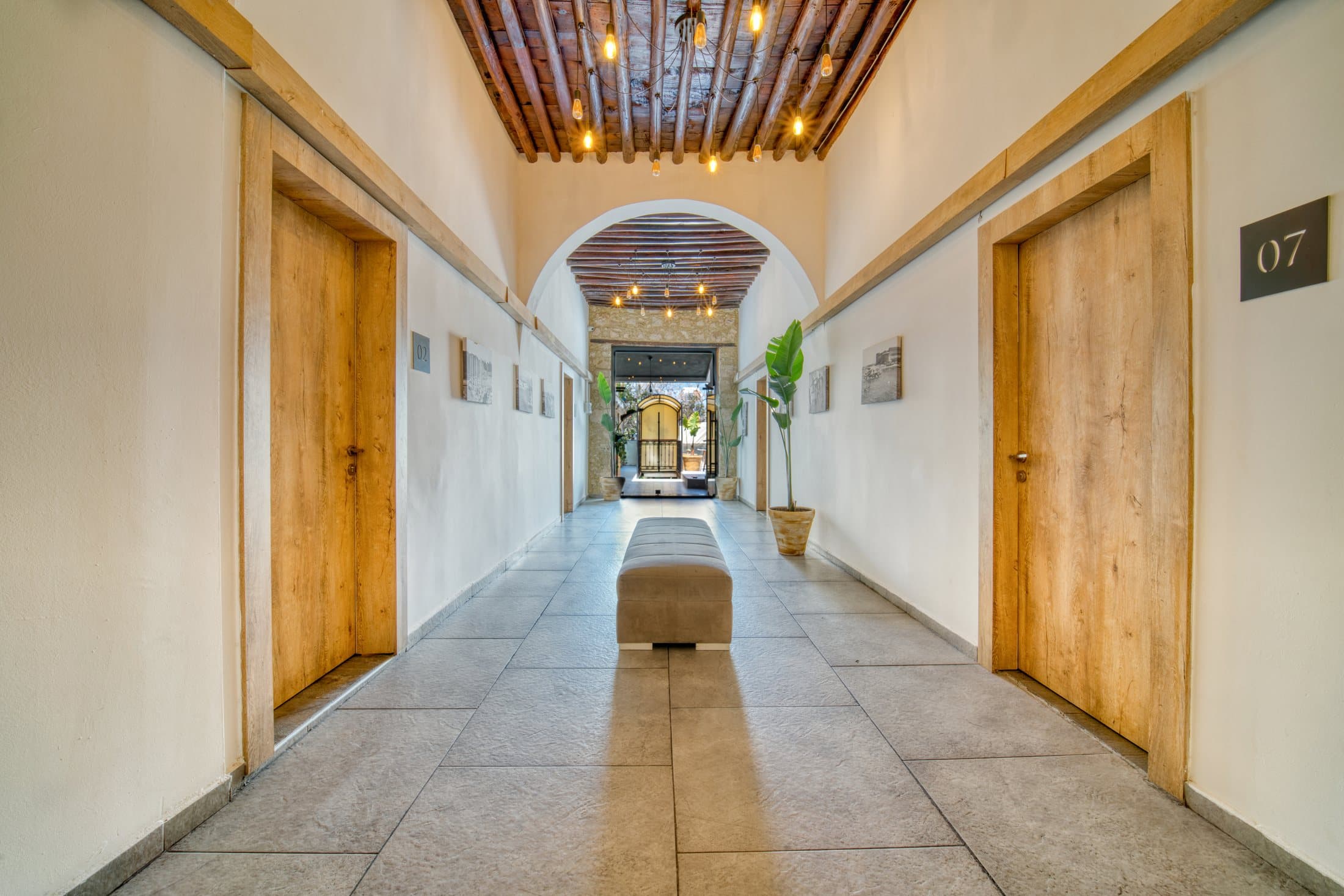 The arched corridor at Avenue Hotel, Girne — warm wood and soft light
